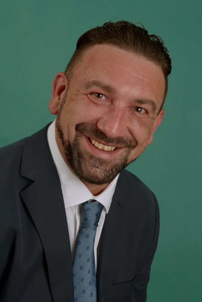 eine Person lächelt im Mantel